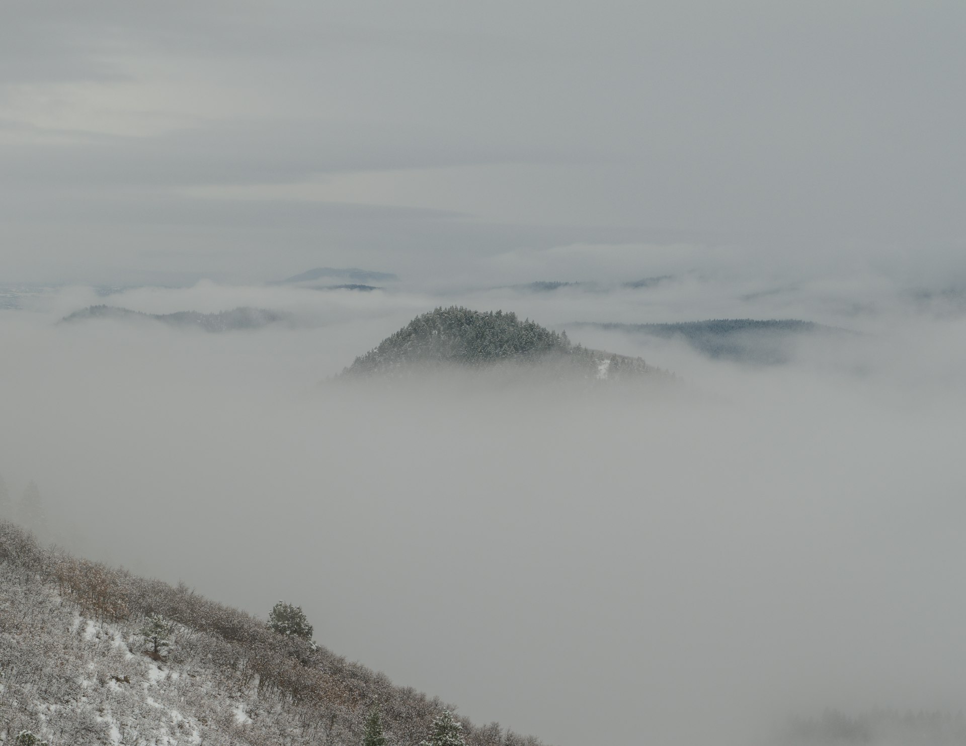 a mountain covered in fog and low lying clouds